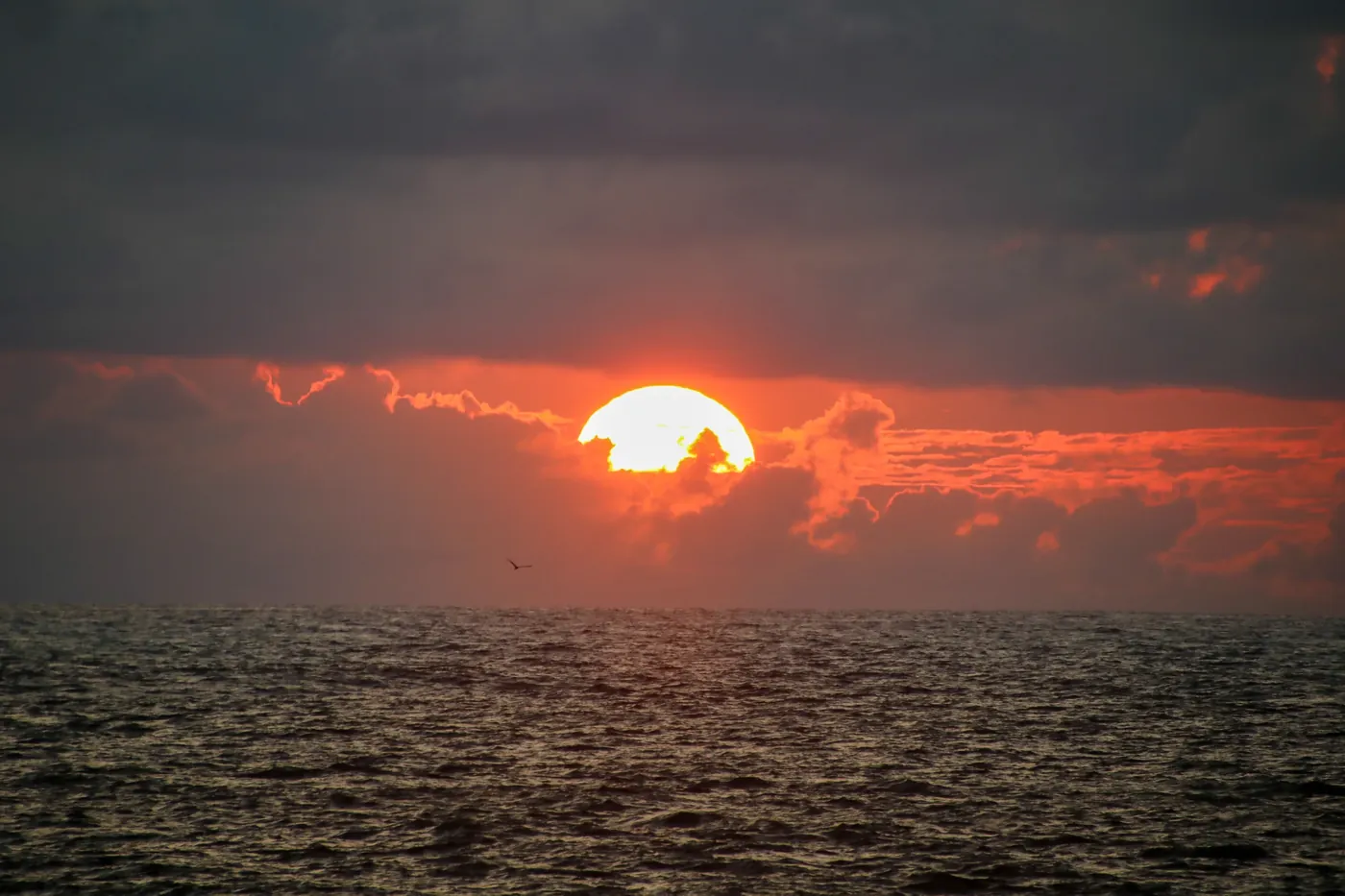 The sun setting into clouds over the Pacific Ocean